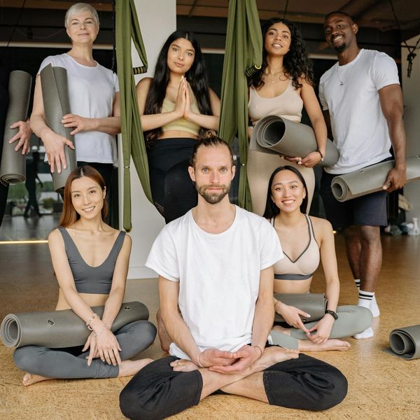 Diverse group of people smiling during a yoga class.